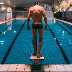 mężczyzna stojący nad basenem
